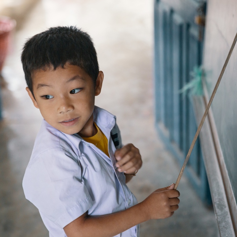 A first-grade student points to letters at the board as he sounds them out. When he gets stuck, he looks to the teacher for help. Somsanouk Primary School, Pak Ou District, Lao PDR. Credit: GPE/Kelley Lynch